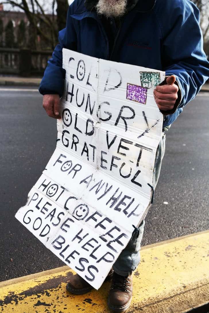 A homeless vet holding a sign for help.